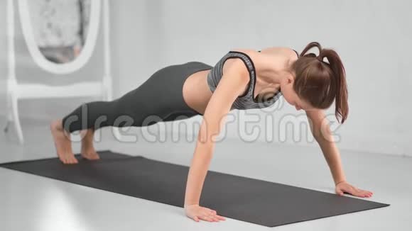 适合肌肉强壮的女士训练地板做向上推在白色家庭内部视频的预览图