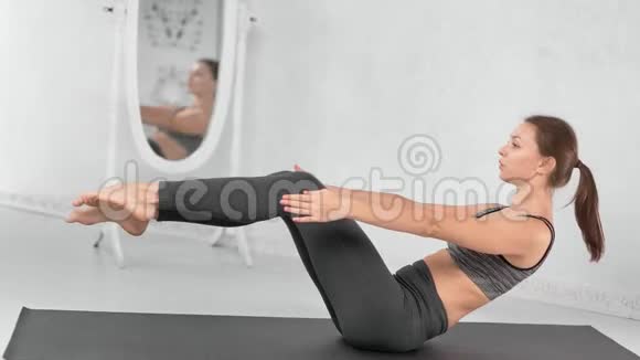 哈代强壮的健身妇女在现代瑜伽工作室的垫子上锻炼腹肌视频的预览图