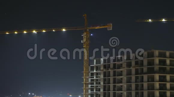 夜间建筑施工时光流逝建筑工地的塔式起重机视频的预览图