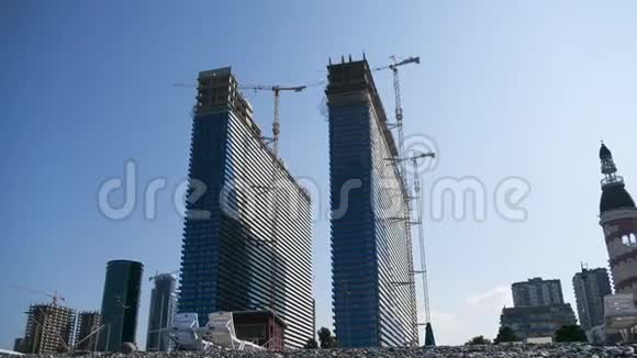 在蓝天的背景下使用摩天大楼建造现代摩天大楼的时间视频的预览图