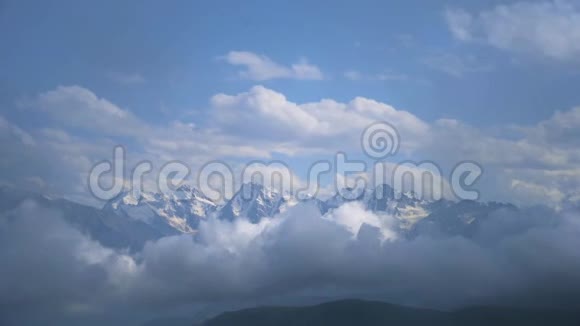 在蓝色多云的天空下有雪的山的冬季景观快速移动云的视频视频的预览图