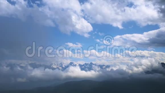 在蓝色多云的天空下有雪的山的冬季景观快速移动云的视频视频的预览图