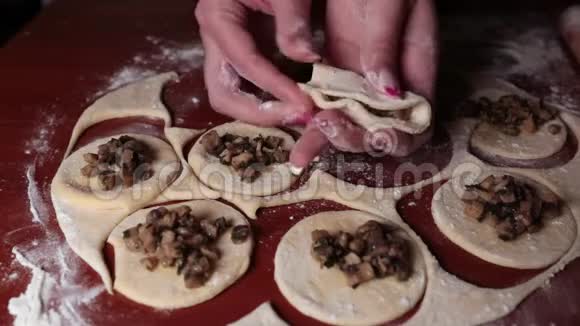 女性的手形成了一个装满蘑菇的饺子的形状视频的预览图