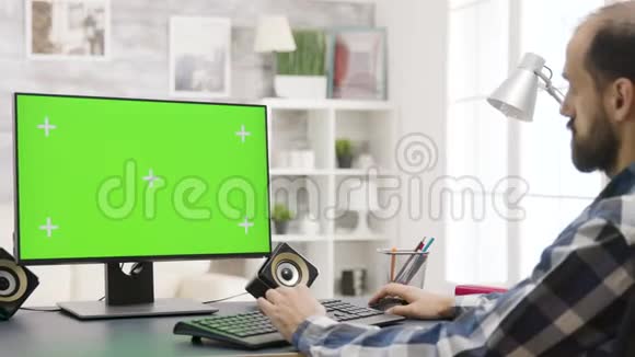 男人看绿色屏幕PC显示在明亮的家视频的预览图