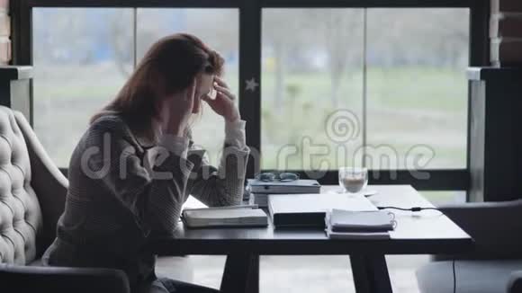 年轻悲伤的女孩正因为工作的砧板和生意中的会计问题而坐着心烦意乱抱着她视频的预览图