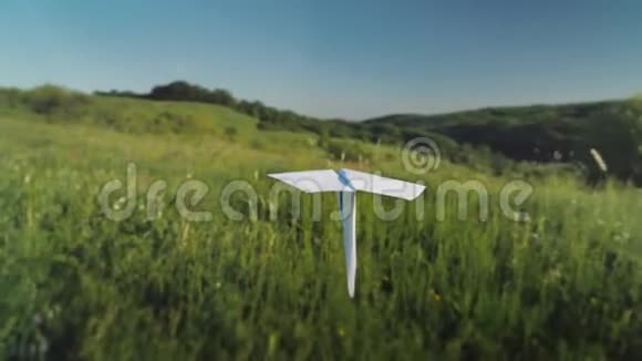 一架真正的纸飞机正飞过一个风景如画的山谷跟随射击视频的预览图