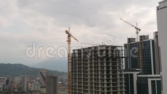 建筑施工建筑工地上的塔式起重机在高层建筑中提升负荷时间推移视频的预览图