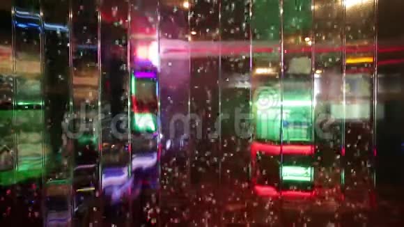 透明玻璃上的彩色气泡模糊了夜总会或赌场内部的墙壁视频的预览图