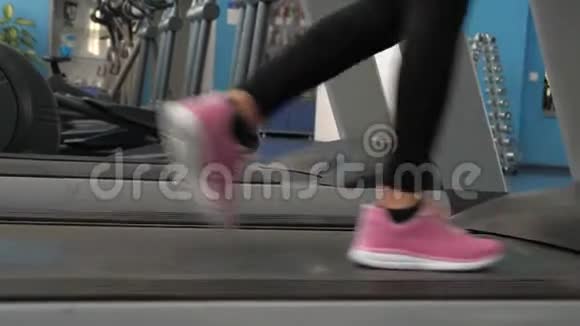体育生活理念穿运动鞋的女孩的腿沿着跑步机走特写镜头加强腿部肌肉视频的预览图