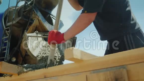工人从工业搅拌机中取出混凝土作为铲子工作施工现场重体力劳动低视频的预览图