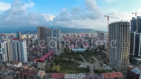 从白天到夜晚城市空间与建筑工地摩天大楼交通和山脉时光流逝格鲁吉亚巴统视频的预览图