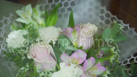 在花店橱窗里特写一束新鲜的玫瑰和百合花视频的预览图