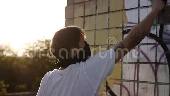高加索人正在为涂鸦做准备在废弃的建筑物上用滚筒漆涂涂成米色视频的预览图