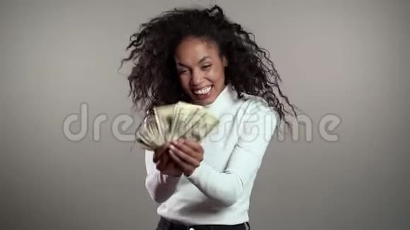 满意兴奋的非洲女人展示金钱美元视频的预览图