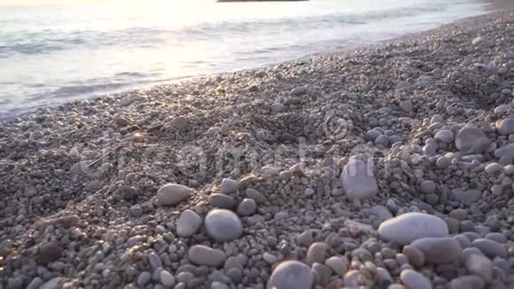 海滩上的石头海岸海洋海岸海浪海边的卵石日出日落视频的预览图