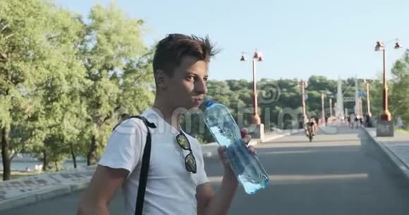 少年男孩喝瓶水夏日炎炎河桥背景视频的预览图