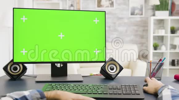 男性手在明亮明亮的绿色屏幕PC上打字视频的预览图