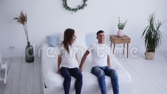 有趣的男人和女人掉在床上互相看着对方接吻年轻夫妇躺在床上投标视频的预览图