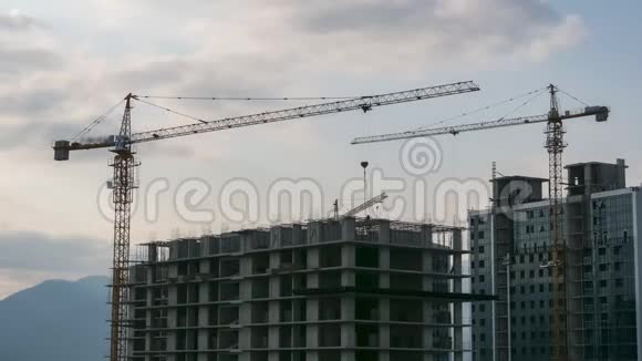 建筑施工时光流逝建筑工地上的塔式起重机在高层建筑中提升负荷视频的预览图