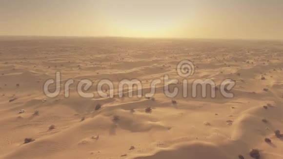 阿联酋沙漠旅游汽车在沙丘上行驶的空中镜头视频的预览图