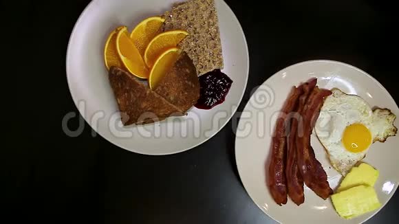 一个旋转的自上而下的两个盘子充满传统的早餐食品在一张桌子上高清24FPS视频的预览图