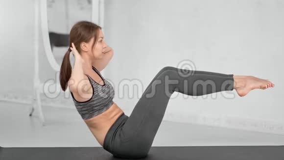 耐力年轻健身女孩在腹肌锻炼中呼吸身体躺在垫子上视频的预览图