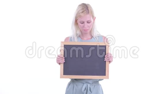 一个年轻的金发女郎站在黑板前听到坏消息视频的预览图