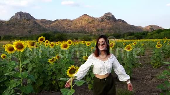 泰国罗布里高珍莱欢快的女人与向日葵一起奔跑和享受视频的预览图