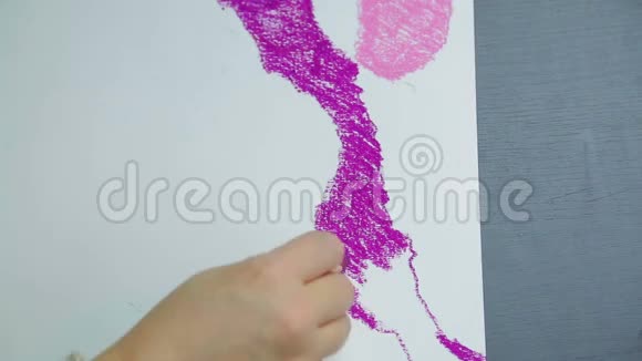 日落时女人的手在白纸上画着紫色的彩纸视频的预览图