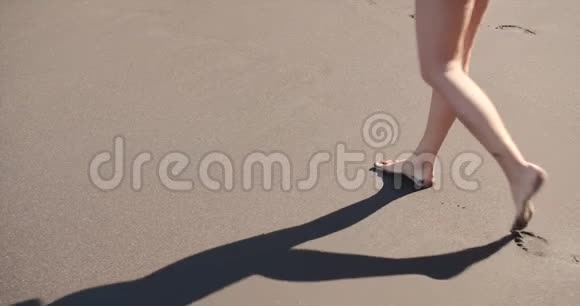 女人的脚在沙滩上赤脚行走在沙滩上留下脚印视频的预览图