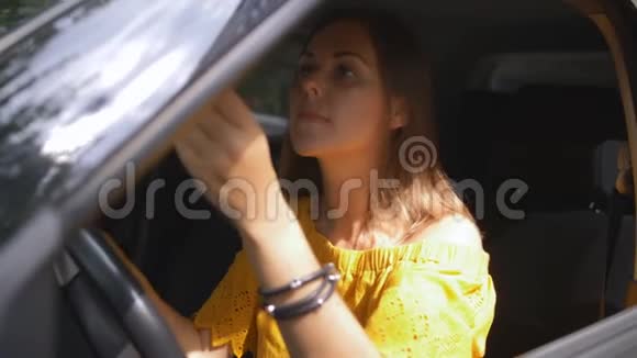 优雅的女人在车里照镜子戴上太阳镜视频的预览图
