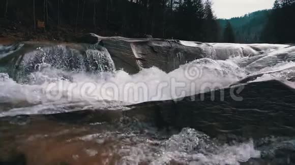 山溪和石急流与雪水的快速流动冬季瀑布慢动作视频的预览图