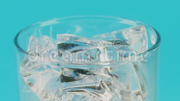 在蓝色背景下将可乐倒入一个装满冰块的玻璃杯中在红色上缓慢移动视频的预览图