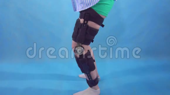 一位年轻女子受伤后蹲着膝盖弯曲膝盖支撑蓝色背景视频的预览图
