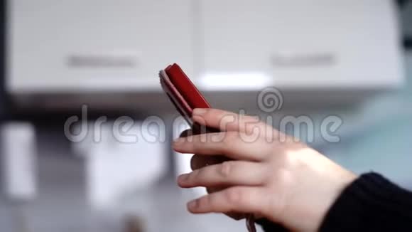 一个女人手中的红色手机视频的预览图