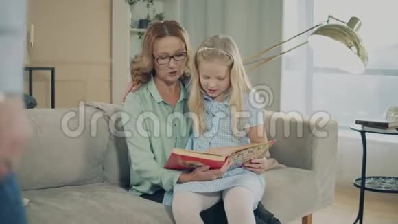 一个女孩和她奶奶和爷爷一起读一本书视频的预览图