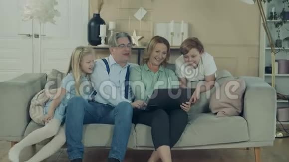孩子们和他们的祖父母在使用笔记本电脑时都在笑视频的预览图