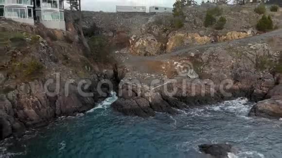 空中无人机拍摄的温哥华岛海岸线崎岖不平靠近克附近有一个现代化的海景公寓视频的预览图