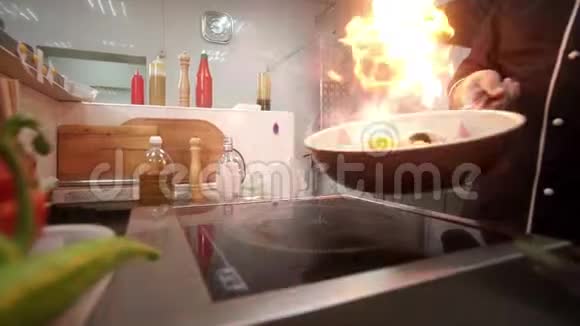 男人用手在平底锅里煎烤燃烧的蔬菜把它们辗转视频的预览图