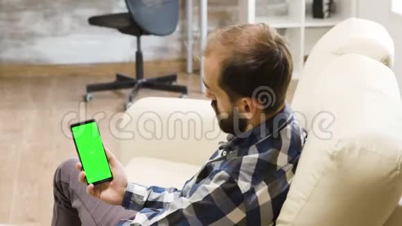 拍了拍年轻人的肩膀看着绿屏手机视频的预览图