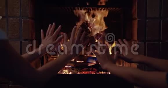 两只手在火炉旁温暖着他的手手的特写镜头视频的预览图