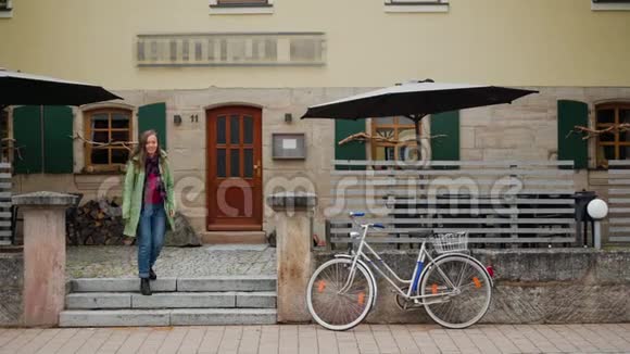 穿绿大褂的漂亮女孩离开餐厅露台骑自行车去了德国巴伐利亚视频的预览图