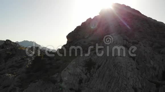 空中无人驾驶飞机俯瞰岩石山顶阳光照射太阳光和太阳光使景色更加美丽视频的预览图