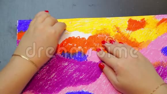 一个女人在日落时分用橙色粉笔完成了一幅画的天空风景画视频的预览图