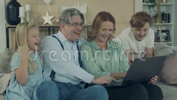 祖父母和孙子孙女们都在用笔记本电脑笑视频的预览图