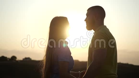 一个留胡子的年轻人和他的女朋友拥抱依偎在一起亲吻的剪影年轻迷人的夫妇视频的预览图