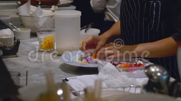 女人手在准备和装饰鲜花泰式甜点在盘子上视频的预览图