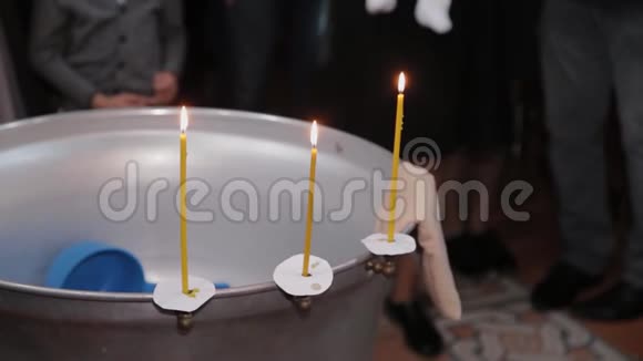 在东正教教堂用燃烧的蜡烛洗礼婴儿的字体视频的预览图