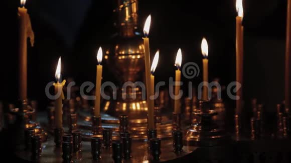 在教堂礼拜时在烛台上点燃教堂的蜡烛视频的预览图