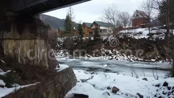 一条半冻结的河流在房屋和铁路之间流动视频的预览图